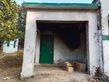 Köydeki Sarkari okulunun ahşap fırın mutfağı, Hint devlet okulunun kil ocağı ve kirli mutfağı. Ocağın üzerinde duman, tehlike, ihmal. 20 Aralık 2022, Varanasi, Hindistan.