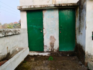 toilet door locked of government primary school, mostly student go outdoor for toilet. The toilet of students in schools in India clipart