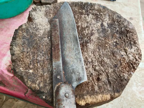 butcher knife and cleaver on a wooden block at a meat shop in an Asian market. A butcher block with knife and meat clove at a shop in India.