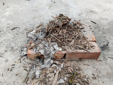 Sarı ve turuncu renkli ateşli alevlerle izole edilmiş güzel bir şenlik ateşi. Kış mevsiminde çevreyi sıcak tutmak için yakılacak odunların eksik yanmasını tasvir ediyor..