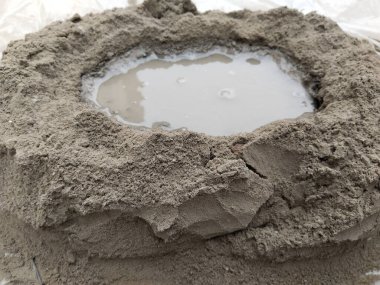 İnşaat işlerinde kürek kullanılarak karıştırılmadan önce çimento ve su. Beton duvar ve zeminde kullanmak üzere kum ve küçük çakıl ile karıştırılmış çimento.