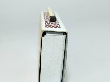 Kazıma yüzeyindeki bir kibriti yakın çekim. Kibrit kutusunun çarpıcı yüzeyi ile yakılan bir kibrit