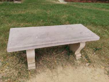 Parkta taş bir bank. Taş desenli sandalye 