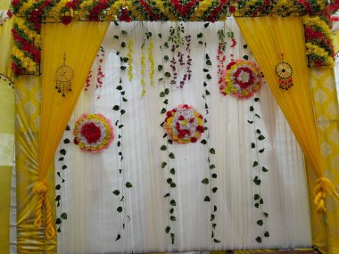 Plastik yapraklar ve çiçeklerle güzel bir düğün sahnesi. Zarif Hint düğün sahnesi dekorasyonu geçmişi. Konferans, düğün ve parti için çadır