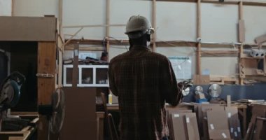 Fabrikada iş görüşmesi yapan Afrikalı marangoz, cep telefonuyla planları tartışıyor. Yüksek kalite 4k görüntü