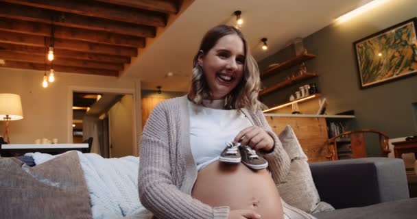 Fun Loving Pregnant Female Sitting Her Sofa Playing Baby Shoes — Wideo stockowe