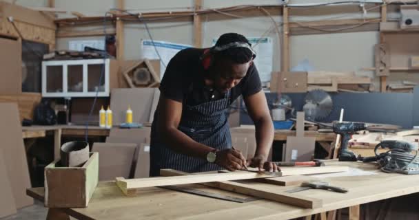 Африканский Плотник Карандашом Руке Сосредоточен Своем Новом Дизайне Деревянных Работ — стоковое видео