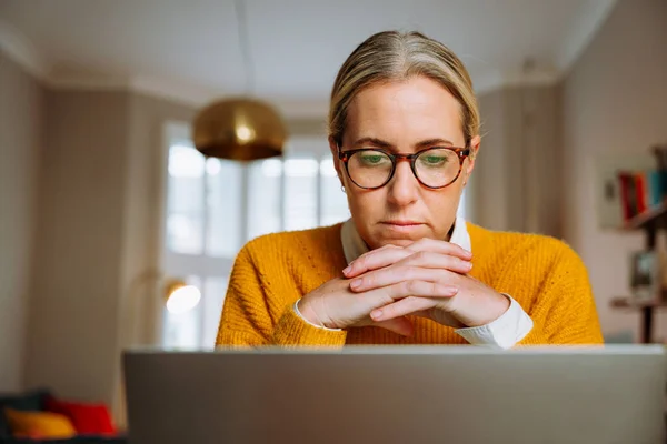 白人女性が家で働いてるノートパソコンを見て机に座ってた 高品質の写真 — ストック写真