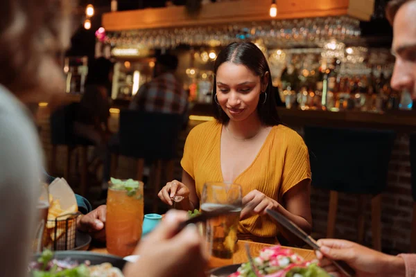Çeşitli arkadaş grupları akşam yemeği için dışarıda lezzetli yemekler yiyor ve kokteyller içiyor. Yüksek kalite fotoğraf