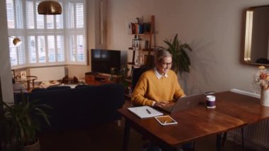 Beyaz kadın iş görüşmesinde kameraya el sallıyor. Evden çalışıyor. Yüksek kalite 4k görüntü