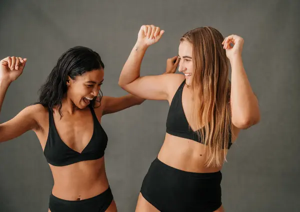 Two girlfriends with different body types in their underwear having fun in the studio. High quality photo
