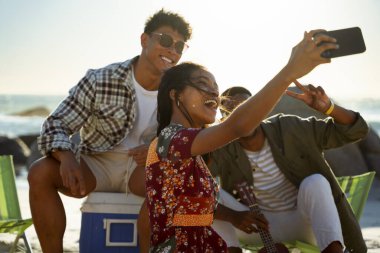 Arkadaşlar gün batımında sahilde selfie çekiyorlar. Yüksek kalite fotoğraf