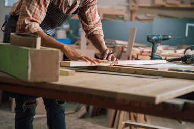 Marangozluk fabrikasında tahta üzerine kalem çizen Afrika kökenli Amerikalı bir erkek resmi. Yüksek kalite fotoğraf