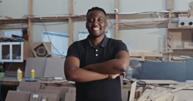 Genç Afrikalı erkek, marangozluk fabrikasında kolları bağlı poz veriyor. Yüksek kalite 4k görüntü
