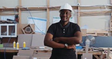 Genç Afrikalı erkek marangoz fabrikasında video için poz veriyor. Yüksek kalite 4k görüntü