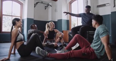 Spor eğitmeni, spor salonundaki gruba egzersiz planını açıklıyor. Yüksek kalite 4k görüntü
