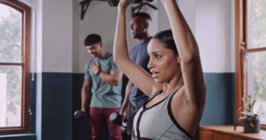 Güzel formda bir kadın spor salonunda dambıllar kullanarak uyukluyor, fitness üzerinde çalışıyor. Yüksek kalite 4k görüntü