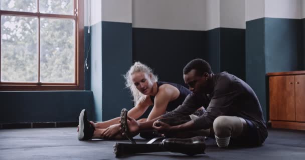 女培训师在训练前与非洲残疾跑步者一起进行伸展训练 高质量的4K镜头 — 图库视频影像
