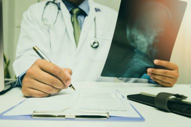 Doktor hastanın röntgen filmini teşhis edip analiz ediyor..