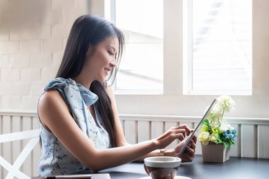 Ofis masasında tablet bilgisayarla çalışan iş kadını..