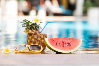 Yaz tatili tropik konsepti. Yüzme havuzunun kenarında taze su kavunu ve ananas..