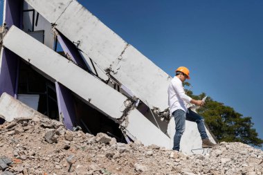 Dizüstü bilgisayarı tutan mühendis yıkımı kontrol ediyor, binayı yıkıyor..