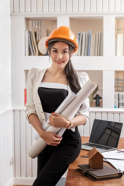 Kvinnlig Arkitekt Eller Ingenjör Som Håller Ritningar Vid Skrivbordet — Stockfoto