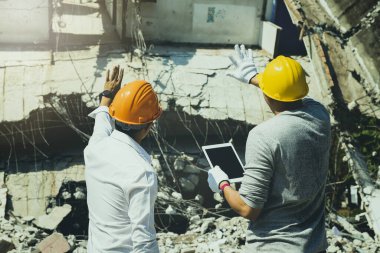 Yıkım kontrol şefi ve müteahhit binayı yıkmayı tartışıyorlar..