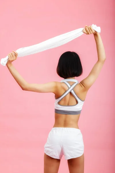 Stock image Young asian woman with towel and headphone on neck isolated on pink background. Healthy lifestyle concept.