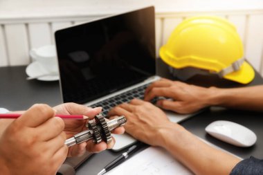 Mühendislik ekibi projelerinde birlikte çalışıyorlar. Caliper ile adam çalışma motor dişli ölçü, motor parçası.