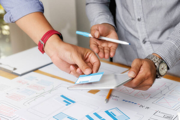 UX or UI designers designing on their smartphone application layout prototype project.