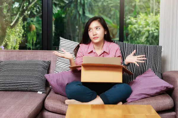 Woman raised her palm with parcel box and feel disappointed after received damaged item or unwanted stuff. Annoyed customers dissatisfied by delivery service.