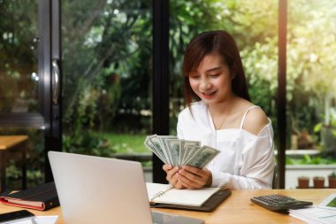 Güzel genç bir kadın bize dolar sayıyor. iş, finans, tasarruf, bankacılık ve çevrimiçi alışveriş kavramı.