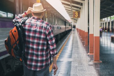 Tren istasyonunda sırt çantalı bir yolcu. Seyahat kavramı.
