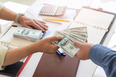 Adam yüz dolarlık banknotlar teklif ediyor. Ortağına para veren bir işadamının eli. İş adamından el ile para almak. Venality, rüşvet, yolsuzluk konsepti.