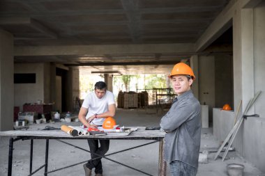 Mimar, Mühendis, Müteahhit ya da İnşaat Müdürü inşaat alanında kol çapraz duruyor..