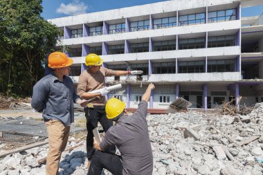 Yıkım kontrol şefi ve müteahhit binayı yıkmayı tartışıyorlar..