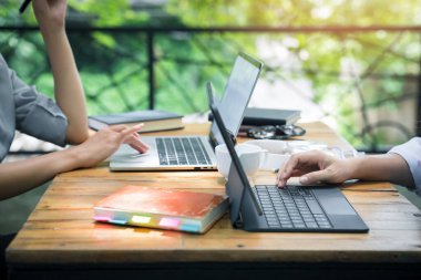 İki genç iş kadını kafeteryada dizüstü bilgisayar ve akıllı telefon kullanarak masada oturuyor. Blog yazarları çalışıyor. Akıllı telefon kullanan bir kadın, iş görüşmesi..