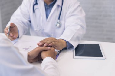 Doktorun elini tutması cesaret, empati, tezahürat ve tıbbi muayene sırasında destek için. Kötü haber azaltma, ilaç ve sağlık hizmetleri kavramı.
