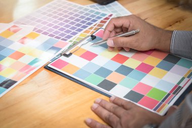 İç mimar ev tasarımı için bir renk şeması seçer. Grafik tasarımcıları modern ofiste renk çizelgesi üzerinde çalışıyorlar.