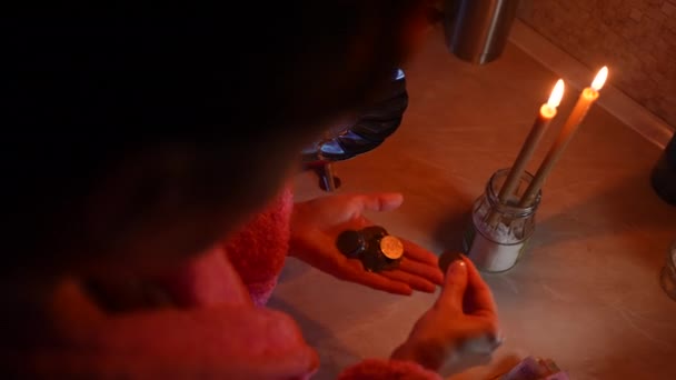 一个女孩用烛光把水放在煤气炉上的杯子里加热 然后数着乌克兰人的钱 乌克兰战争 没有电和煤气 — 图库视频影像