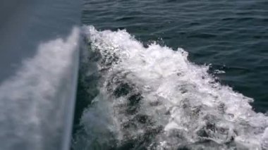 The bow of a white yacht cuts the waves in the sea. Slow motion