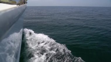 The bow of a white yacht cuts the waves in the sea. Slow motion