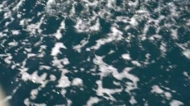 The bow of a white yacht cuts the waves in the sea. Slow motion