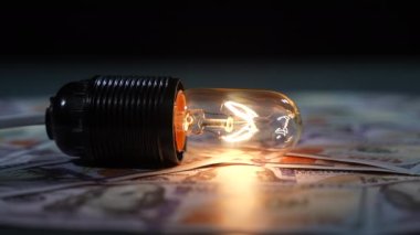 Dolar banknotlarında çekiçle parlak bir elektrik lambasını kırmak. yavaş çekim
