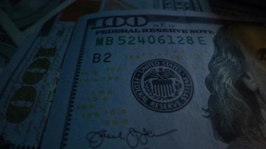 Masanın üzerinde parlayan bir lamba bulunan dolar banknotları. Dolly vurdu.