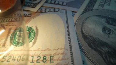 Masanın üzerinde parlayan bir lamba bulunan dolar banknotları. Dolly vurdu.