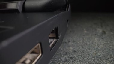 USB tapası eski siyah bir laptoptan çıkarılıyor. Yakın plan. Dolly vurdu.