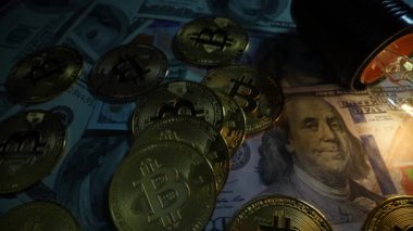 100 dolarlık banknotlar, bitcoin paralar ve parlayan elektrik lambaları. Dolly vurdu.