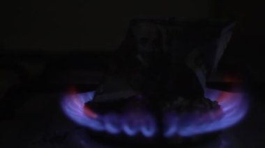 100 dolarlık banknot bir gaz sobasında yanıyor. Ağır çekim. Dolly vurdu.
